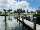 Waterfront view of a wooden dock with a boat lift and a boat sitting on the water at 104 Pops Ln, Nokomis, FL 34275