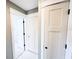 Hallway view of a bathroom and closet doors plus neutral paint and trim throughout at 104 Pops Ln, Nokomis, FL 34275