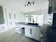 Bright kitchen island with sink and granite counter, complemented by white cabinetry at 104 Pops Ln, Nokomis, FL 34275