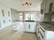 Bright kitchen features granite countertops, an island sink, ample cabinetry, and backyard access at 104 Pops Ln, Nokomis, FL 34275