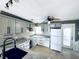 Well-lit kitchen features gray and white cabinets, granite countertops, and black hardware at 104 Pops Ln, Nokomis, FL 34275