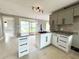 Bright kitchen features granite countertops, an island sink, ample cabinetry, and backyard access at 104 Pops Ln, Nokomis, FL 34275