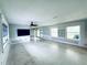Expansive living room with a ceiling fan, natural light from two windows, and patio access for seamless indoor-outdoor living at 104 Pops Ln, Nokomis, FL 34275