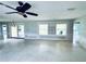 Spacious living room featuring ample natural light, ceiling fan, and sliding door access to outdoor space at 104 Pops Ln, Nokomis, FL 34275
