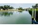 Expansive canal view showcasing the waterway, and neighborhood homes under an overcast sky at 104 Pops Ln, Nokomis, FL 34275