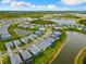An aerial view displays homes bordering a lake in a meticulously planned community with pristine landscaping at 10868 Sun Drop St, Venice, FL 34293