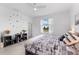 Bright bedroom featuring a comfortable bed, stylish decor, and a view of the outdoors at 10868 Sun Drop St, Venice, FL 34293