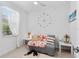 Bedroom featuring cozy seating area, a large wall clock, and natural light at 10868 Sun Drop St, Venice, FL 34293