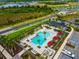 Overhead shot of a modern community pool area with palm trees, cabanas, and plenty of lounge chairs at 10868 Sun Drop St, Venice, FL 34293