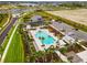 An aerial view of a sparkling community pool surrounded by palm trees and ample lounge space at 10868 Sun Drop St, Venice, FL 34293
