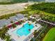 Aerial view of a resort-style community pool with cabanas, palm trees, and manicured landscaping at 10868 Sun Drop St, Venice, FL 34293