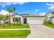 Charming one-story home with a two-car garage, well-manicured lawn, and beautiful palm trees at 10868 Sun Drop St, Venice, FL 34293
