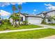 Beautiful single-Gathering home with a well-maintained lawn, paver driveway, and tropical landscaping at 10868 Sun Drop St, Venice, FL 34293