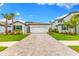 Charming single Gathering home featuring a two-car garage, well-manicured lawn and tropical landscaping at 10868 Sun Drop St, Venice, FL 34293