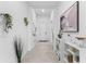 Bright hallway features neutral tile, white shelving, modern art, and plant accents at 10868 Sun Drop St, Venice, FL 34293