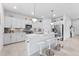 Bright kitchen with white cabinets, a central island with seating, and stainless steel appliances at 10868 Sun Drop St, Venice, FL 34293