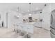 Modern kitchen with white cabinetry, a large center island with seating, and stainless steel appliances at 10868 Sun Drop St, Venice, FL 34293
