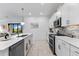 Open kitchen with white countertops, sleek appliances, tile backsplash, and modern lighting at 10868 Sun Drop St, Venice, FL 34293