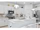 Stylish kitchen featuring stainless steel appliances, a white countertop island, and modern light fixtures at 10868 Sun Drop St, Venice, FL 34293