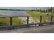 Scenic lake view from the community walking path, featuring a wooden bridge with steel cable railing at 10868 Sun Drop St, Venice, FL 34293