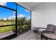 Lanai with tile flooring, comfortable chairs, and picturesque pond view at 10868 Sun Drop St, Venice, FL 34293