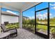 Lanai with tile flooring and screen, with a view of the pond at 10868 Sun Drop St, Venice, FL 34293
