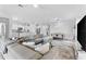 Bright, open-concept living space featuring a spacious sectional sofa, modern kitchen and dining area at 10868 Sun Drop St, Venice, FL 34293