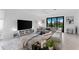 Bright living room with a large gray sectional sofa, modern decor, and view of outdoors at 10868 Sun Drop St, Venice, FL 34293