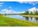 Scenic view of a serene pond surrounded by lush greenery and beautiful homes under a bright blue sky at 10868 Sun Drop St, Venice, FL 34293
