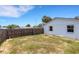 Fenced backyard with grass and a white home exterior shows secure space and potential for outdoor activities at 112 E Marland Ct, Nokomis, FL 34275