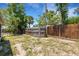 View of the property's fenced backyard with some tropical trees at 112 E Marland Ct, Nokomis, FL 34275