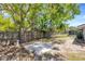 Shaded backyard with concrete patio, wooden fence, and mature trees at 112 E Marland Ct, Nokomis, FL 34275