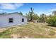 Side view of a white home with a backyard featuring grass and a wooden fence, offering privacy at 112 E Marland Ct, Nokomis, FL 34275