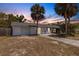 Charming single-story home with a one car garage and lush palm trees in the front yard at 112 E Marland Ct, Nokomis, FL 34275
