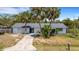 Charming single-story home with a one car garage and lush palm trees in the front yard at 112 E Marland Ct, Nokomis, FL 34275