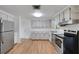 Bright kitchen features stainless steel appliances, white cabinets and counter tops, and wood floors at 112 E Marland Ct, Nokomis, FL 34275