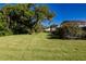 Sprawling backyard with mature trees, lush lawn, and vibrant landscaping at 1279 Vermeer Dr, Nokomis, FL 34275