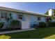 Light-blue home exterior featuring a well-kept lawn, tropical landscaping, and a fenced-in patio at 1279 Vermeer Dr, Nokomis, FL 34275