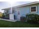 Light-blue home exterior featuring a well-kept lawn, tropical landscaping, and a white door at 1279 Vermeer Dr, Nokomis, FL 34275