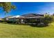 Lush backyard with screened lanai, landscaping and green lawn at 1279 Vermeer Dr, Nokomis, FL 34275