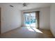 Sunlit bedroom featuring carpet and sliding glass doors overlooking the pool and backyard at 1279 Vermeer Dr, Nokomis, FL 34275