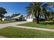 A charming light-blue home with a well-maintained lawn and tropical landscaping at 1279 Vermeer Dr, Nokomis, FL 34275