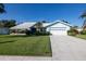 Charming light-blue home with a well-manicured lawn, landscaping, and a two-car garage at 1279 Vermeer Dr, Nokomis, FL 34275