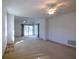 Bright living room featuring carpeted floors, ceiling fans, a window, and a large sliding glass door to the outside at 1279 Vermeer Dr, Nokomis, FL 34275