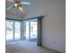 View of the living room and exterior pool area with large sliding glass doors and a ceiling fan at 1279 Vermeer Dr, Nokomis, FL 34275