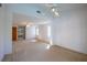 Bright living room with carpeted floors, white walls, two windows, and a doorway to the bathroom at 1279 Vermeer Dr, Nokomis, FL 34275