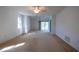 Spacious living room with white walls, carpeted floors, ceiling fans, and sliding glass doors to the outside at 1279 Vermeer Dr, Nokomis, FL 34275