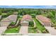 Aerial view of a well-maintained home with a red tile roof, lush landscaping, and a serene lake backdrop at 13108 Torresina Ter, Bradenton, FL 34211
