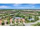 Scenic aerial view of houses with red tile roofs surrounding a pond, showcasing the beautiful neighborhood at 13108 Torresina Ter, Bradenton, FL 34211