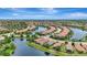 Beautiful aerial view of residential homes and a pond with lush green landscaping under a blue sky at 13108 Torresina Ter, Bradenton, FL 34211